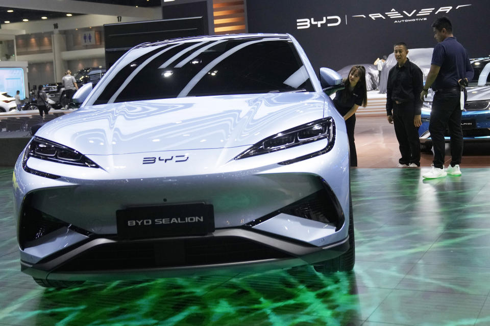 Visitors look at an electric vehicle from China's BYD during the 45th Bangkok Motor Show in Nonthaburi , Tuesday, March 26, 2024. Thailand. (AP Photo/Sakchai Lalit)