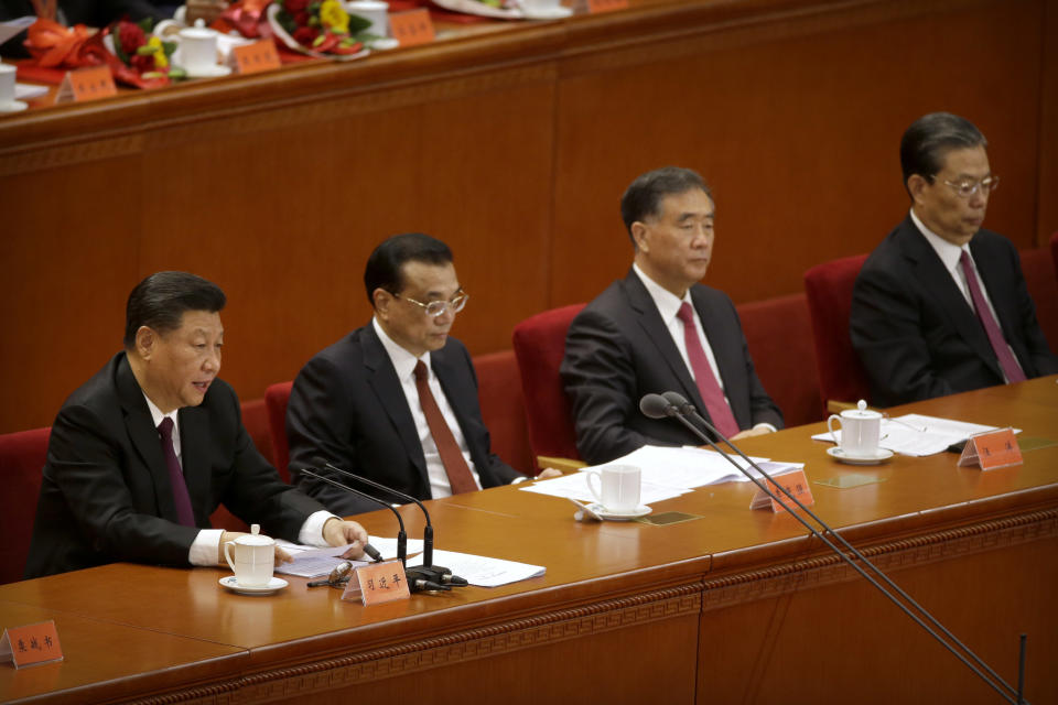 Chinese President Xi Jinping, left, speaks during a conference to commemorate the 40th anniversary of China's Reform and Opening Up policy at the Great Hall of the People in Beijing, Tuesday, Dec. 18, 2018. (AP Photo/Mark Schiefelbein)