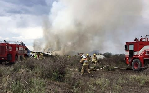 Rescue workers and firefighters reach the site of the crash - Credit: Civil Defence Office of Durango via AP