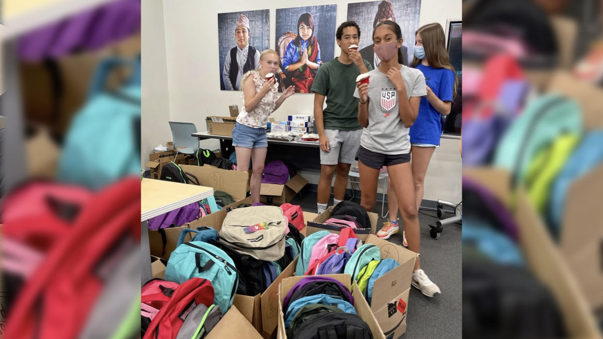 Lily, left, and friends at New American Pathways with some of the backpacks for Afghanistan refugee children going back to school. (Photo: New American Pathways)