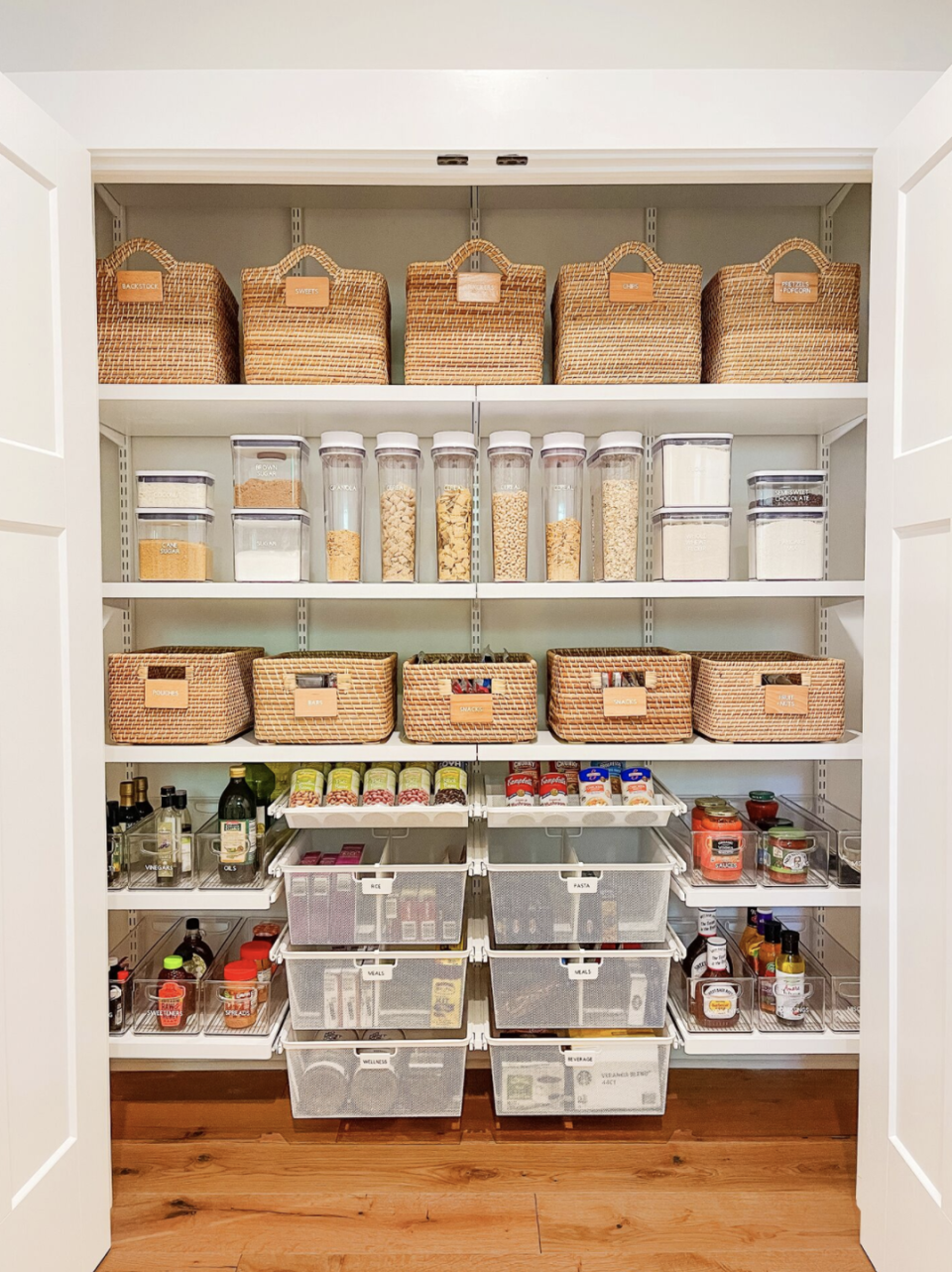 pantry organization ideas, opened pantry closet with containers and baskets of food on white shelves