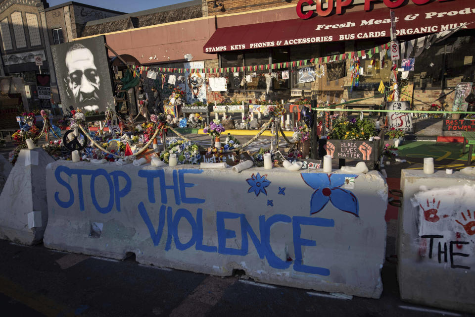 FILE- Barriers placed by the city of Minneapolis surround memorials as community members gather in George Floyd Square, June 7, 2021. Several stores where George Floyd was killed by Minneapolis police in 2020 are suing the city for about $1.5 million. The lawsuit by Cup Foods and several other businesses accuses the city of not policing the area and blocking customers from the businesses. (AP Photo/Christian Monterrosa)