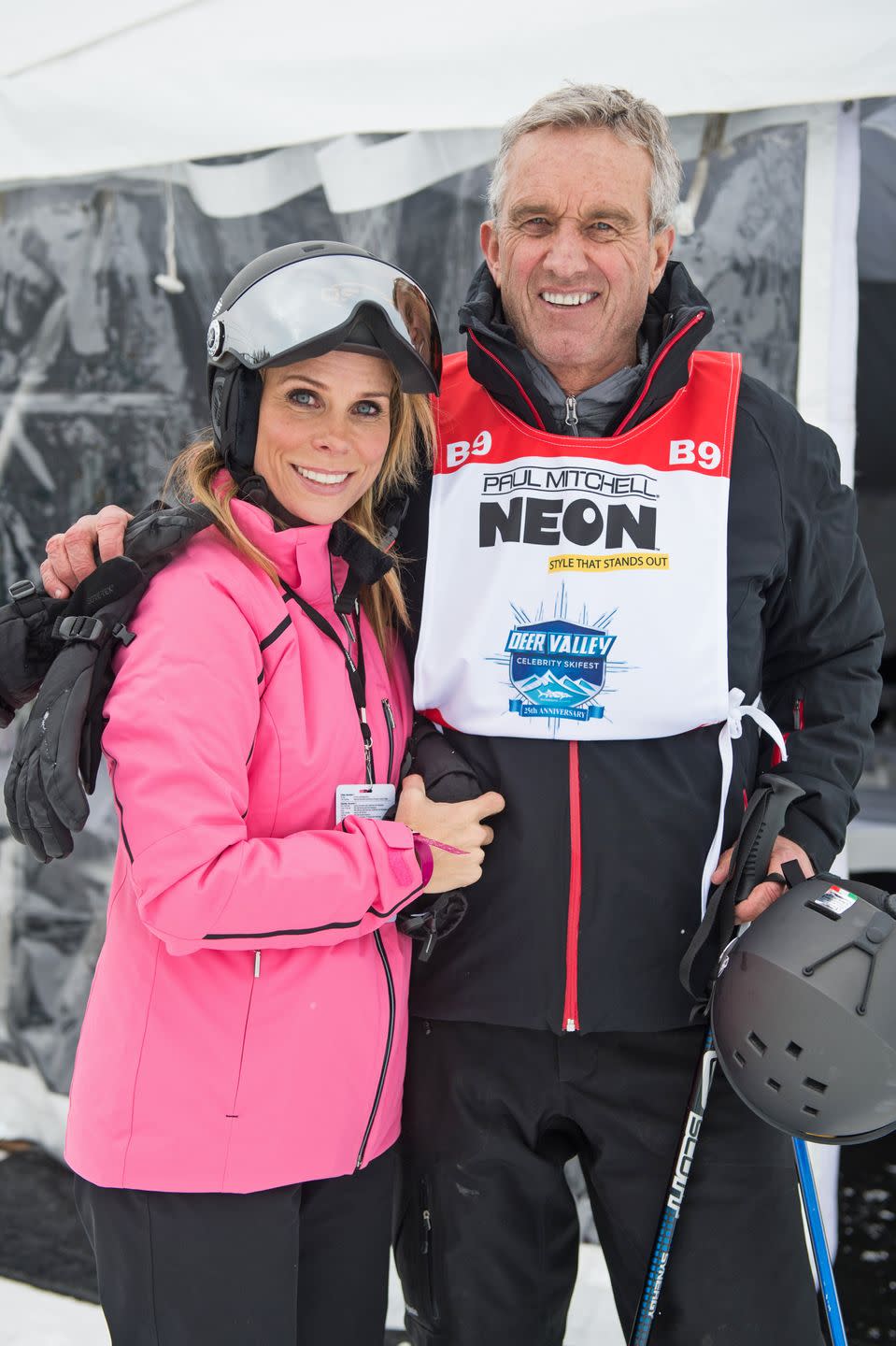 cheryl hines and robert f kennedy jr smile at the camera, they are wearing skiing apparel