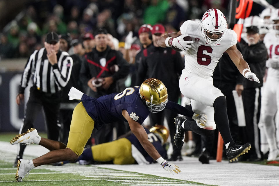 Stanford wide receiver Elijah Higgins, right, jumps as he runs with the ball past Notre Dame safety Brandon Joseph during the second half of an NCAA college football game in South Bend, Ind., Saturday, Oct. 15, 2022. Stanford won 16-14. (AP Photo/Nam Y. Huh)