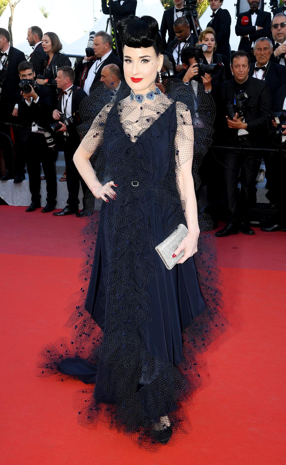 Dita dons a navy V-neck dress with lace overlay and accessorizes with Chopard jewelry at the <em>Rocketman</em> screening.