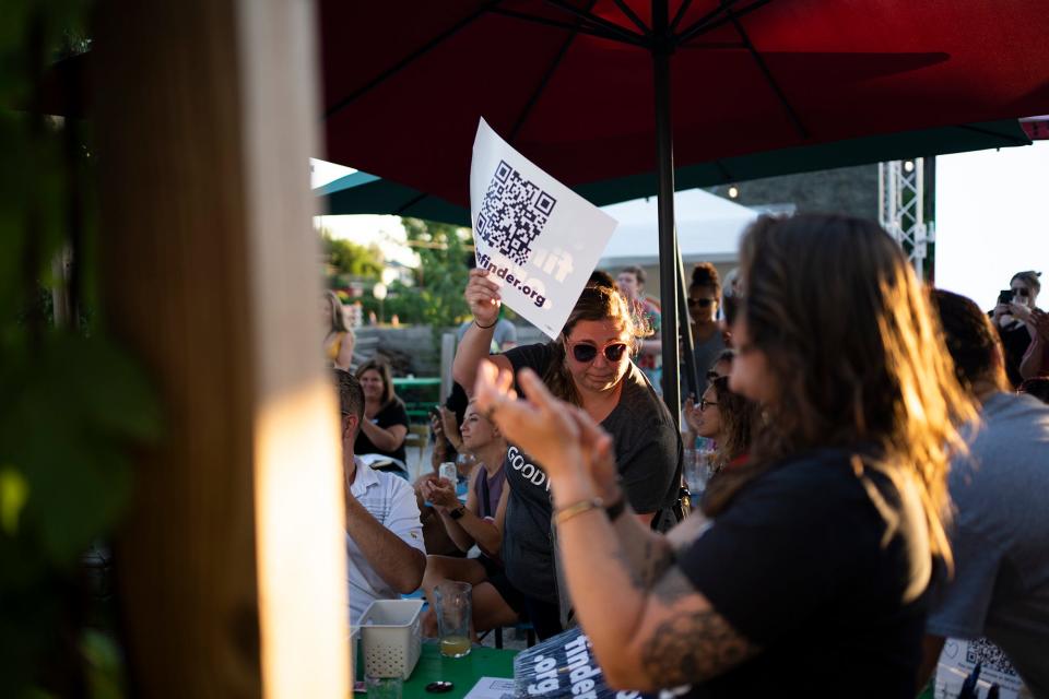 Sarah Conn, of London, Ohio, passes out abortionfinder.org signs during a community care event held by abortion rights groups, to offer a space for healing and planning after the Supreme Court struck down Roe v. Wade.