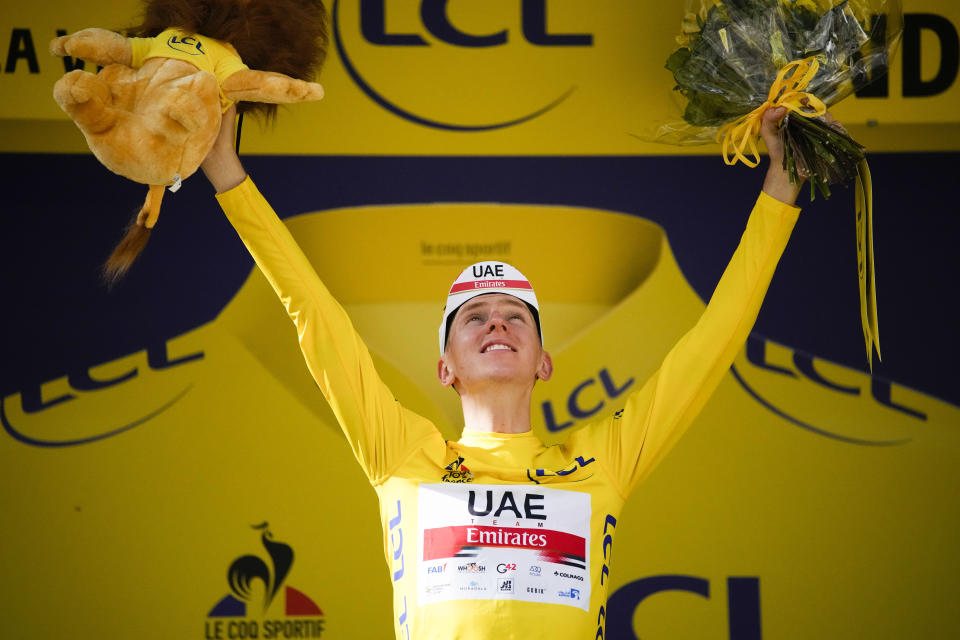 Slovenia's Tadej Pogacar, wearing the overall leader's yellow jersey, celebrates on the podium after the fifteenth stage of the Tour de France cycling race over 191.3 kilometers (118.9 miles) with start in Ceret and finish in Andorra-la-Vella, Andorra, Sunday, July 11, 2021. (AP Photo/Christophe Ena)