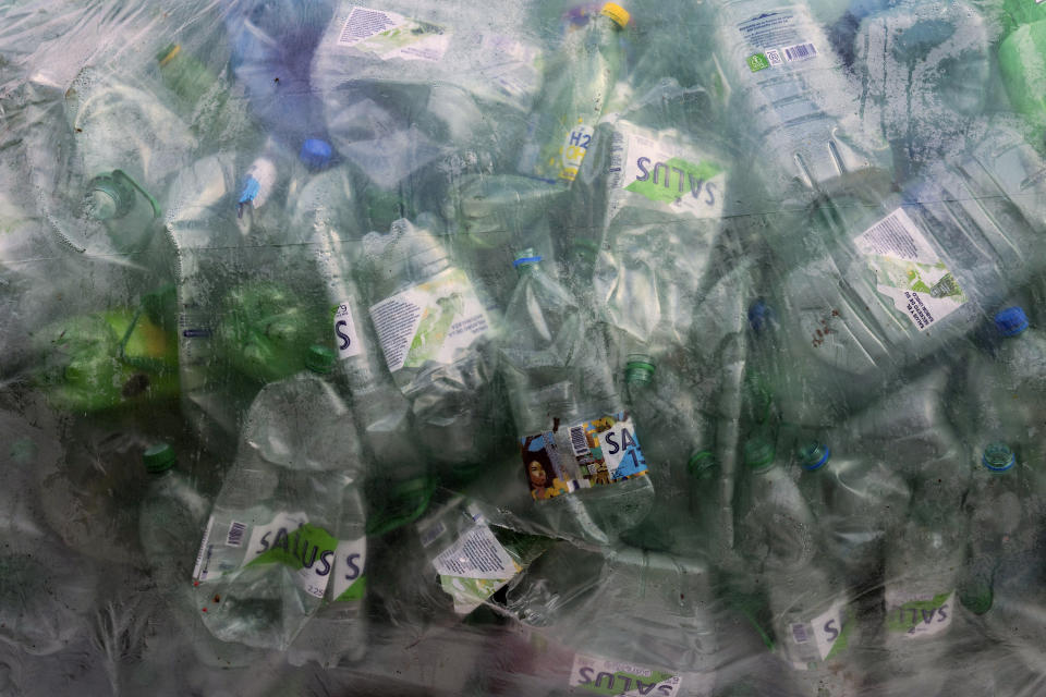 Botellas de agua vacías guardadas en una bolsa de plástico en el patio delantero de un residente después de que fueron recolectadas para reciclarlas en Montevideo, Uruguay, el jueves 22 de junio de 2023. (AP Foto/Matilde Campodonico)