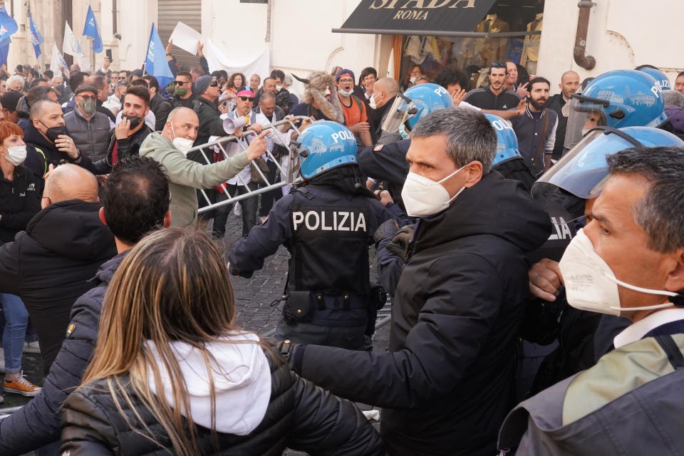 Demonstrators scuffle with Italian Policemen during a protest by Restaurant and shop owners outside the Lower Chamber in Rome, Tuesday, April 6, 2021. Demonstrators demanded to reopen their business and protested against restrictive measures by the Italian Government to cope with the surge of COVID-19 cases. (AP Photo/Andrew Medichini)