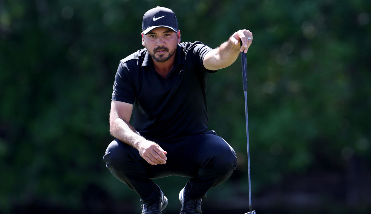  Day lines up a putt whilst wearing a black top and hat 