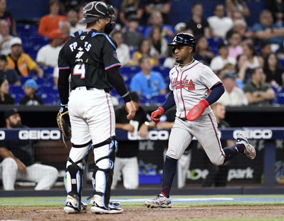 Atlanta Braves' Ronald Acuña Jr. scores in front of Miami Marlins catcher Nick Fortes (4) during the seventh inning of a baseball game Friday, April 12, 2024, in Miami. (AP Photo/Michael Laughlin)