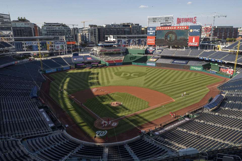 The grounds crew prepares the field before an exhibition baseball game between the Washington Nationals and the Philadelphia Phillies at Nationals Park, Saturday, July 18, 2020, in Washington. (AP Photo/Alex Brandon)