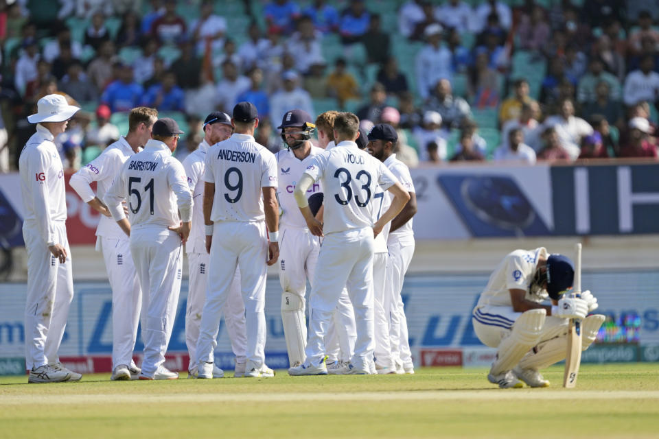 England players celebrate the wicket of India's Shubman Gill, as Kuldeep Yadav squats on the ground, on the fourth day of the third cricket test match between England and India in Rajkot, India, Sunday, Feb. 18, 2024. (AP Photo/Ajit Solanki)