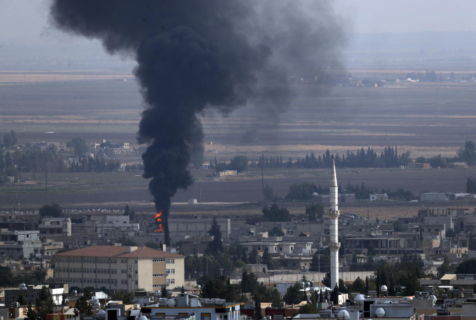 In this photo taken from the Turkish side of the border between Turkey and Syria, in Ceylanpinar, Sanliurfa province, southeastern Turkey, smoke billows from a fire in Ras al-Ayn, Syria, Friday, Oct. 18, 2019. Fighting broke out in the morning hours in the Syrian border town which has been a flashpoint in the fight between Turkey and Kurdish forces despite a U.S.-brokered cease-fire that went into effect overnight. The fighting died down in mid-morning. (AP Photo/Lefteris Pitarakis)