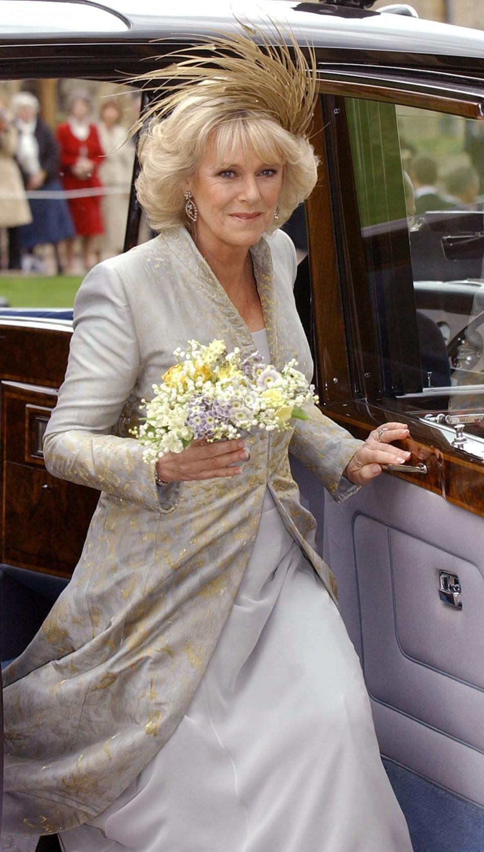 Camilla changed into a floor-length embroidered blue and gold coat over a matching chiffon gown and a dramatic spray of golden feathers in her hair.