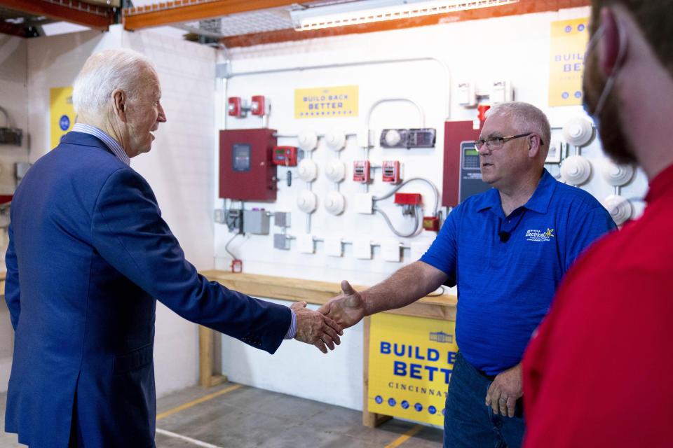 President Joe Biden greets electrician instructor Jerry Mahoney, second from right, and apprentice Stephen Randolph, right, as he arrives to speak with them at the IBEW / NECA Electrical Training Center in Cincinnati, Wednesday, July 21, 2021. (AP Photo/Andrew Harnik)