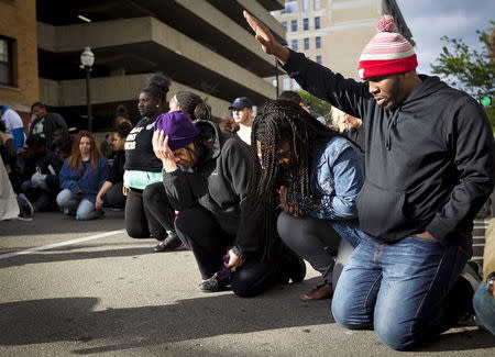 Marchers stop to pray during a rally after a prosecutor said that a police officer will not face charges in the fatal shooting of an unarmed 19-year-old biracial man, in Madison, Wisconsin May 12, 2015. REUTERS/Ben Brewer