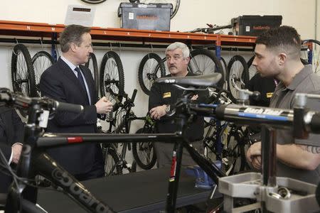 Britain's Prime Minister David Cameron talks to inmate Chris (R) inside the Halfords academy at HMP Onley, where inmates are being trained to become Halford's shop assistants and bicycle technicians in Rugby, central England, February 8, 2016. REUTERS/Christopher Furlong/Pool