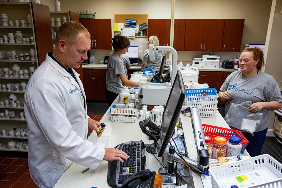 Pharmacist Ashley Buckman, left, and his staff fill prescriptions during a busy afternoon at B & B Pharmacy in Shepherdsville.