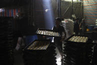 FILE - In this Wednesday, April 7, 2021, file photo, Afghan bakers prepare sweets at a traditional bakery ahead of the upcoming Muslim fasting month of Ramadan, in Kabul, Afghanistan. Muslims are facing their second Ramadan in the shadow of the pandemic. Many Muslim majority countries have been hit by an intense new coronavirus wave. While some countries imposed new Ramadan restrictions, concern is high that the month’s rituals could stoke a further surge. (AP Photo/Rahmat Gul, File)