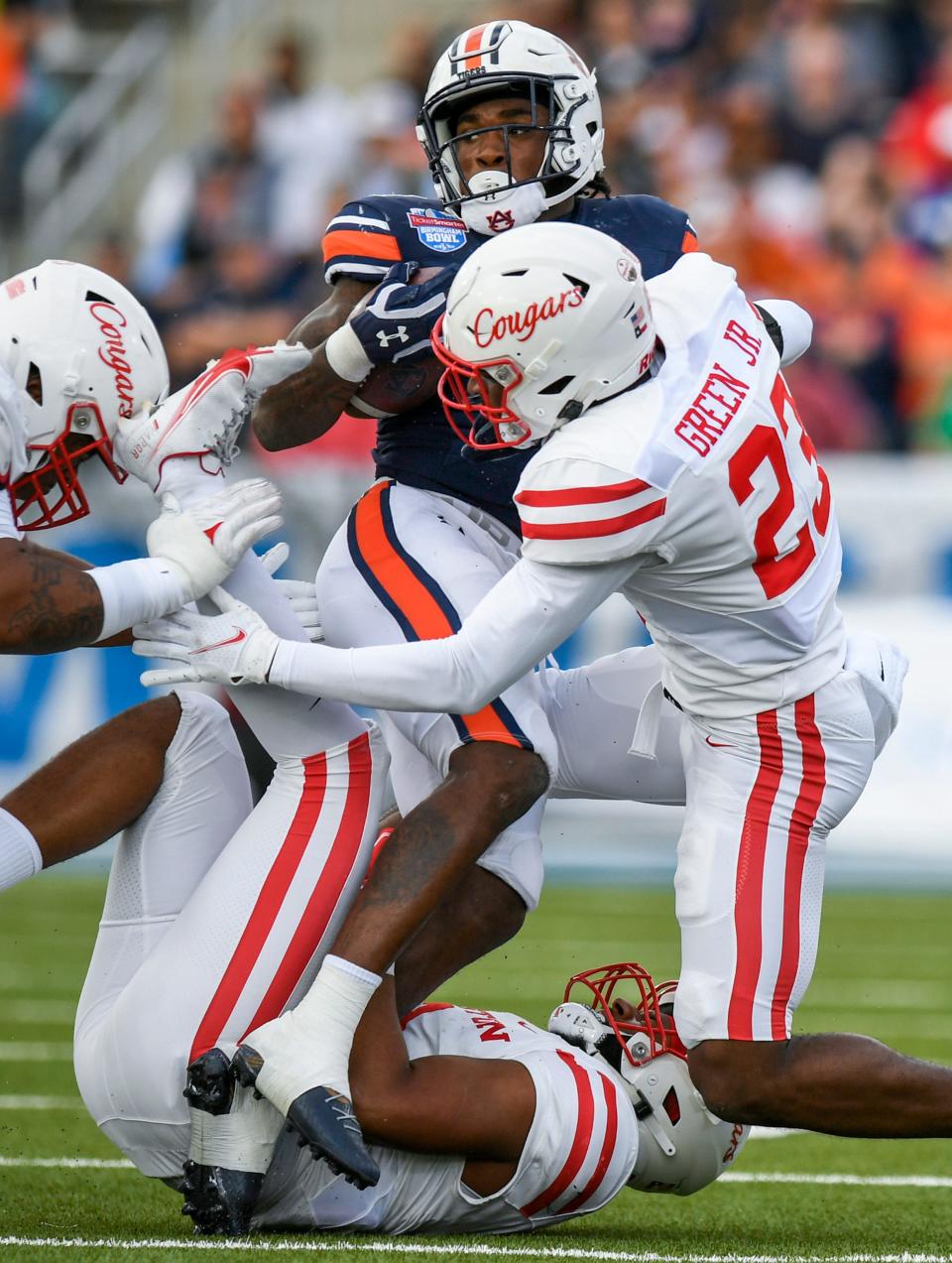 Auburn Tigers running back Tank Bigsby (4) is stopped by Houston linebacker Deontay Anderson (2) and cornerback Art Green (23) during the Birmingham Bowl at Protective Stadium in Birmingham, Ala., on Tuesday December 28, 2021.