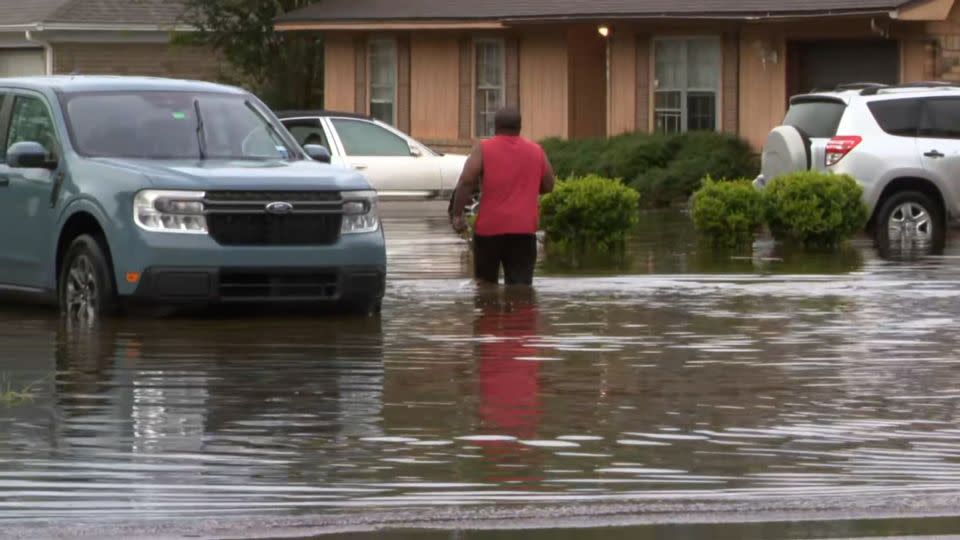 A person walks through floodwater in Pensacola, Florida, Friday. - WEAR
