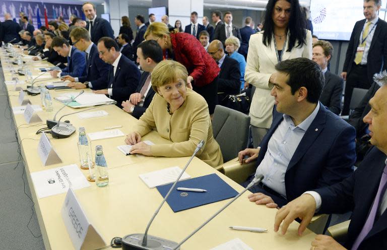 German chancellor Angela Merkel (C) talks with Greek Prime Minister Alexis Tsipras (R) at the EU Eastern Partnership Summit in Riga, on May 22, 2015