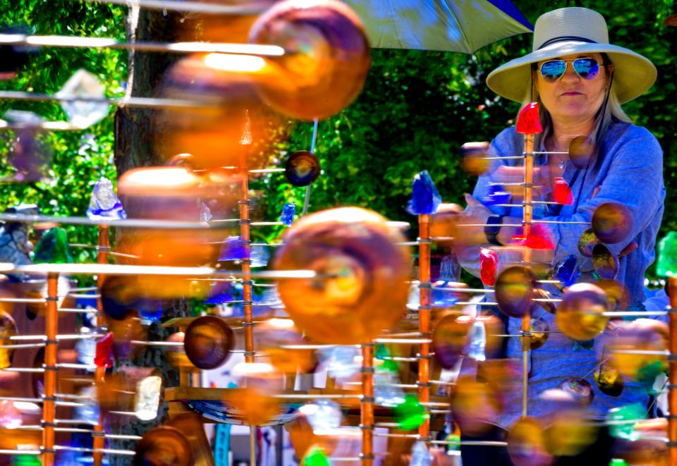 Lisa Cross looks at the kinetic art on display during the opening day of the 2021 Festival of the Arts.