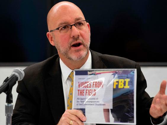 FBI Agents Association’s Thomas O’Connor holds up an FBI report ‘Voices From the Field’ giving examples of how the government shutdown is undermining its work (Getty)