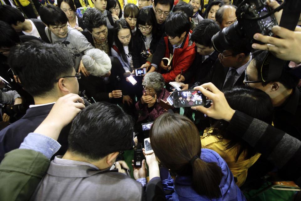 A grandmother of a student who is one of the passengers of a ferry sinking off South Korea's southern coast, talks on a phone as she waits for the news at an auditorium in Danwon High School in Ansan, South Korea, Thursday, April 17, 2014. Strong currents, rain and bad visibility hampered an increasingly anxious search Thursday for more than 280 passengers still missing a day after their ferry flipped onto its side and sank in cold waters off the southern coast of South Korea. (AP Photo/Woohae Cho)