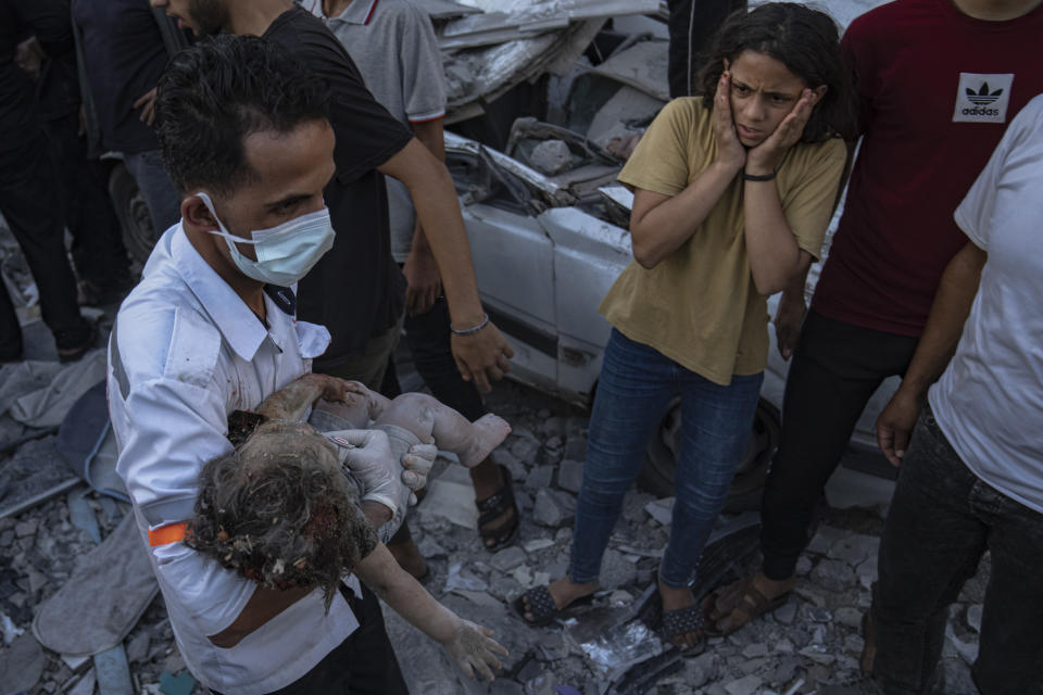Una niña palestina reacciona al ver a otra niña que fue sacada de entre los escombros de un edificio derruido tras un ataque aéreo, en Jan Yunis, Gaza, el 21 de octubre de 2023. (AP Foto/Fatima Shbair)