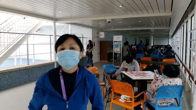 Passengers wear protective masks aboard the World Dream cruise ship, in Hong Kong