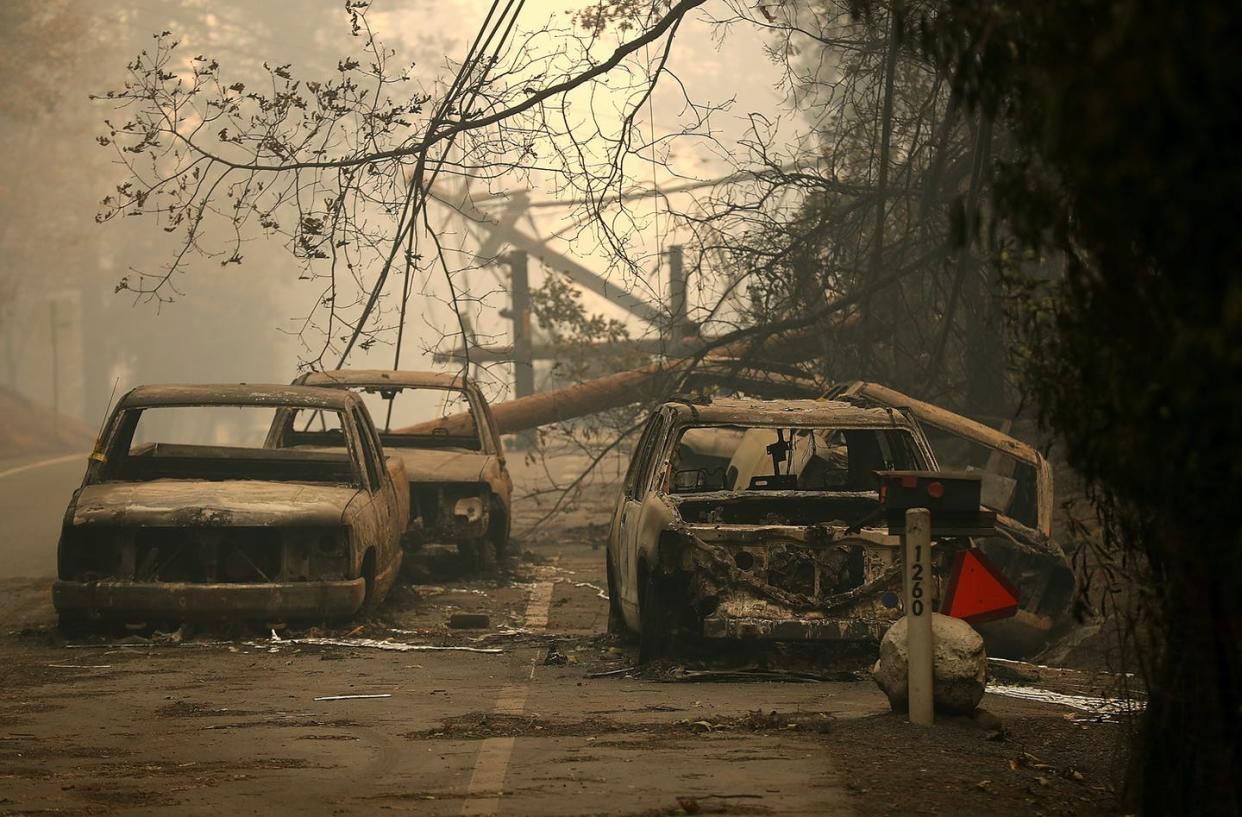 <span class="caption">The 2018 Camp Fire north of Sacramento burned everything in its path: cars, power lines, and buildings – and contaminated local drinking water. </span> <span class="attribution"><a class="link " href="https://www.gettyimages.com/detail/news-photo/power-lines-rest-on-cars-that-were-burned-by-the-camp-fire-news-photo/1060030926?adppopup=true" rel="nofollow noopener" target="_blank" data-ylk="slk:Justin Sullivan/Getty Images;elm:context_link;itc:0;sec:content-canvas">Justin Sullivan/Getty Images</a></span>