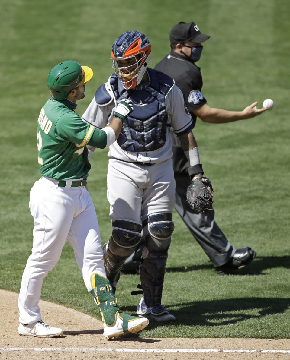 Oakland Athletics' Ramon Laureano, left, speaks with Houston Astros catcher Martin Maldonado after being hit by a pitch thrown by Astro's Humberto Castellanos in the seventh inning of a baseball game Sunday, Aug. 9, 2020, in Oakland, Calif. (AP Photo/Ben Margot)