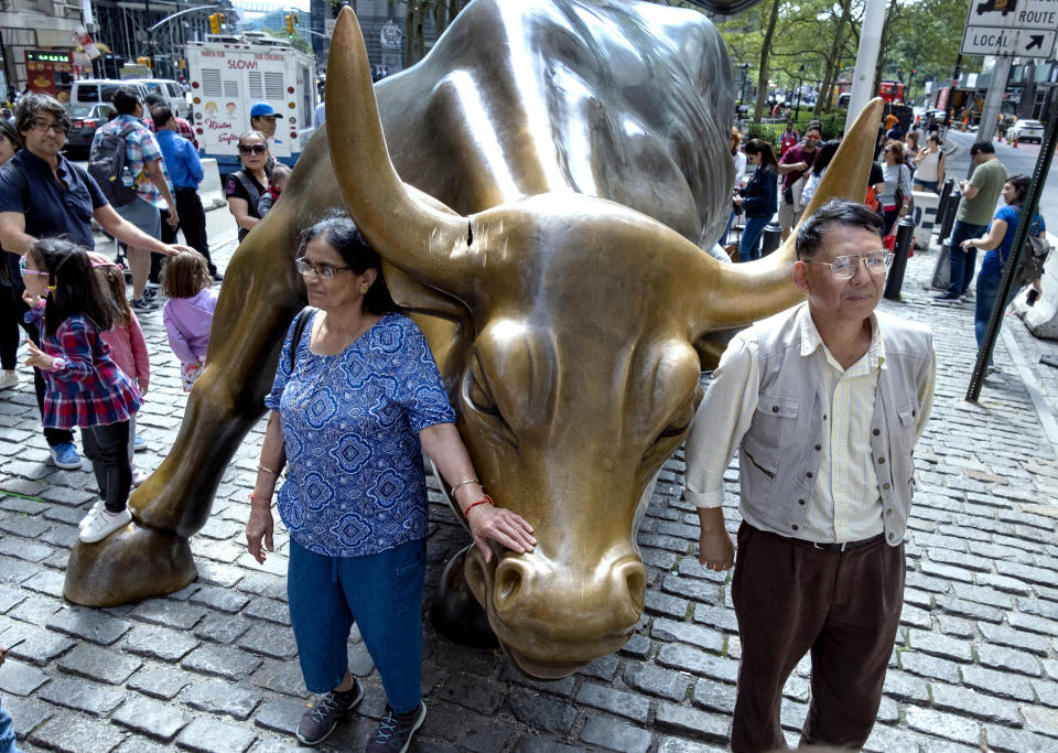People gather around the popular lower Manhattan sculpture "Charging Bull," with a damaged right horn, Sunday, Sept. 12, 2019, in New York. A man was arrested Saturday afternoon for damaging the iconic Wall Street Charging Bull statue with an object resembling a banjo, local media reported. (AP Photo/Craig Ruttle)