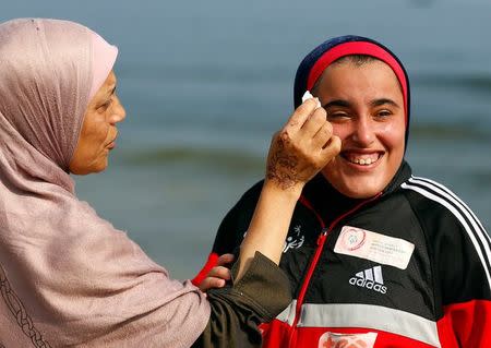 The mother of Special Olympics athlete Esraa Gamal cleans her face on a beach in Alexandria, Egypt, July 18, 2017. REUTERS/Mohamed Abd El Ghany