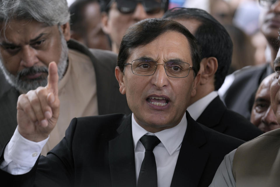 Chairman of Pakistan's Tehreek-e-Insaf party Gohar Khan, center, talks to the media while party supporters react after a Supreme Court decision in a case of reserved seats for women and minorities in parliament, in Islamabad, Pakistan, Friday, July 12, 2024. Pakistan's top court on Friday ruled that the party of imprisoned former Prime Minister Khan is eligible for seats reserved in the parliament, a major blow to the country's weak coalition government. (AP Photo/Anjum Naveed)