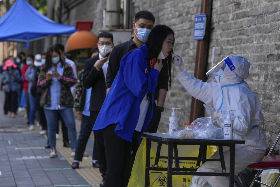 Residents line up for COVID-19 testing in the Chaoyang district on Wednesday, May 11, 2022, in Beijing. Shanghai reaffirmed China's strict "zero-COVID" approach to pandemic control Wednesday, a day after the head of the World Health Organization said that was not sustainable and urged China to change strategies. (AP Photo/Andy Wong)