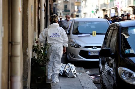 A forensic officer works on the site where mafia boss Giuseppe Dainotti was shot to death in Palermo, Italy May 22, 2017. REUTERS/Guglielmo Mangiapane