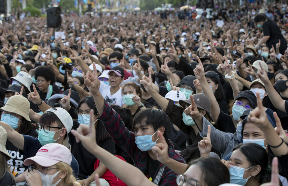 Pro-democracy activities gestures during a protest at Democracy Monument in Bangkok, Thailand, Sunday, Aug, 16, 2020. Protesters have stepped up pressure on the government demanding to dissolve the parliament, hold new elections, amend the constitution and end intimidation of the government's opponents. (AP Photo/Gemunu Amarasinghe)