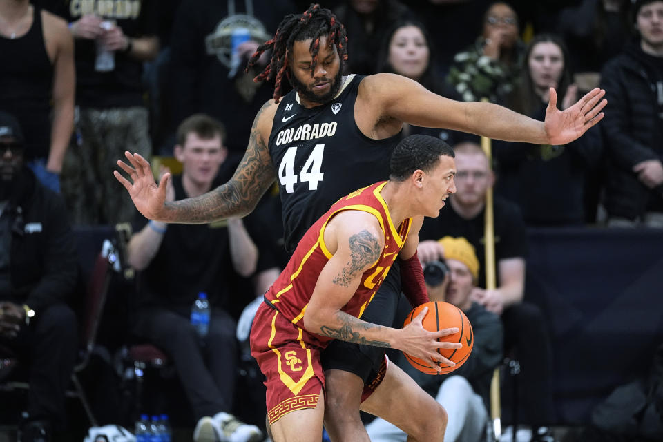 Southern California guard Kobe Johnson, front, is fouled by Colorado center Eddie Lampkin Jr. during the second half of an NCAA college basketball game Saturday, Jan. 13, 2024, in Boulder, Colo. (AP Photo/David Zalubowski)