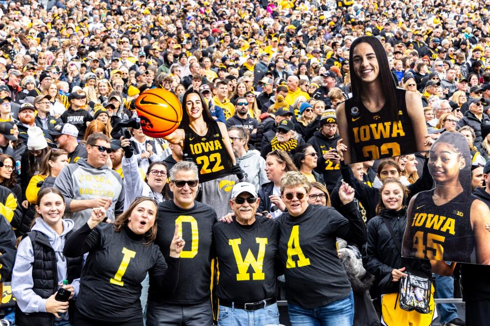 Iowa Hawkeyes fans hold up cutout photos of Iowa guard Caitlin Clark (22) during the Crossover at Kinnick women's basketball scrimmage between Iowa and DePaul, Sunday, Oct. 15, 2023, at Kinnick Stadium in Iowa City, Iowa.