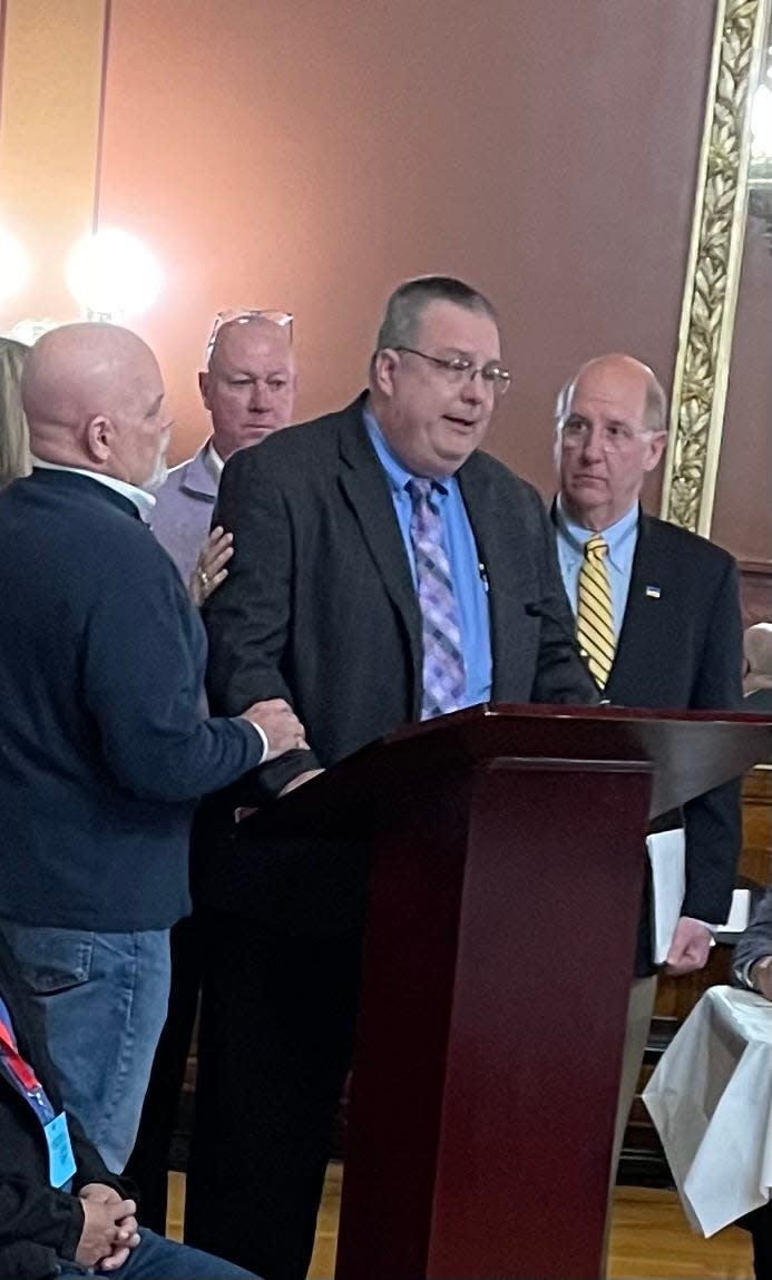 Dennis Laprade, who says his claims of childhood abuse by a Catholic priest went nowhere because of the statute of limitations, breaks down while testifying before the Rhode Island House Judiciary Committee on Thursday night. Standing to support him are, from left, Pasco Troia, Jim Scanlan and Herbert "Hub" Brennan, all victims of childhood sexual abuse.