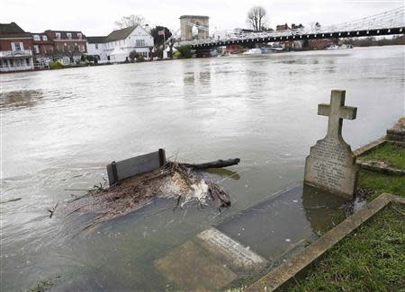 The river Thames floods into a graveyard at All Saints church in Marlow, southern England February 9, 2014. REUTERS/Eddie Keogh
