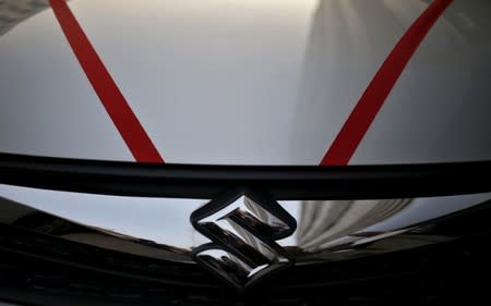 The logo of Maruti Suzuki India Limited is seen on car parked outside a showroom in New Delhi