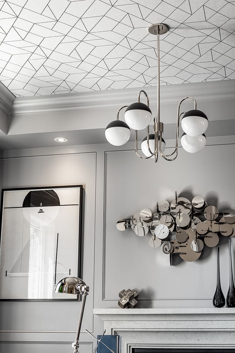 A living room with a low ceiling painted in interesting, geometric patterns