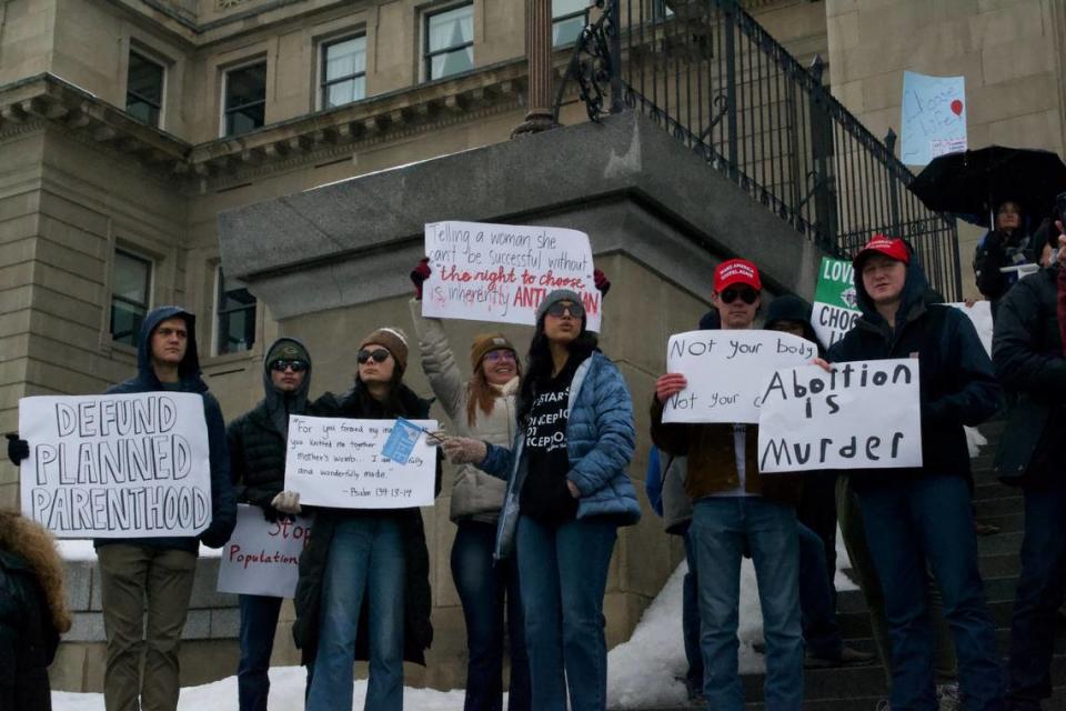 March for Life attendees held signs on the steps of the Idaho State Capitol during speeches against abortion.