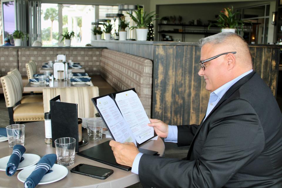 Don Lullo, general manager at Farmer's Table, reads a menu at the North Palm Beach restaurant.