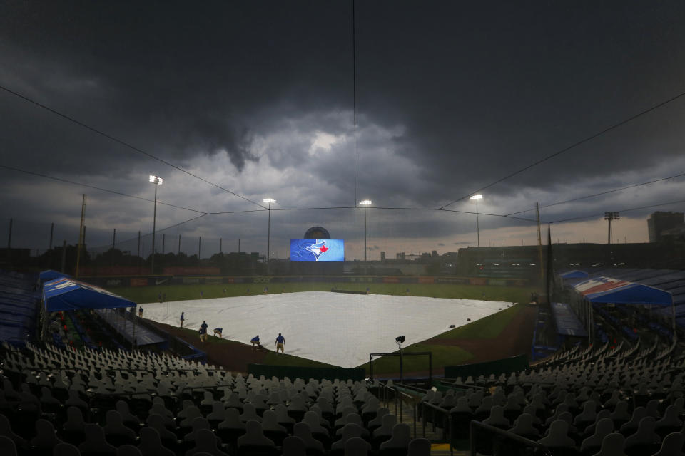 Toronto Blue Jays grounds crew cover field during a rain storm during the fourth inning of a baseball game against the Tampa Bay Rays, Saturday, Aug. 15, 2020, in Buffalo, N.Y. (AP Photo/Jeffrey T. Barnes)