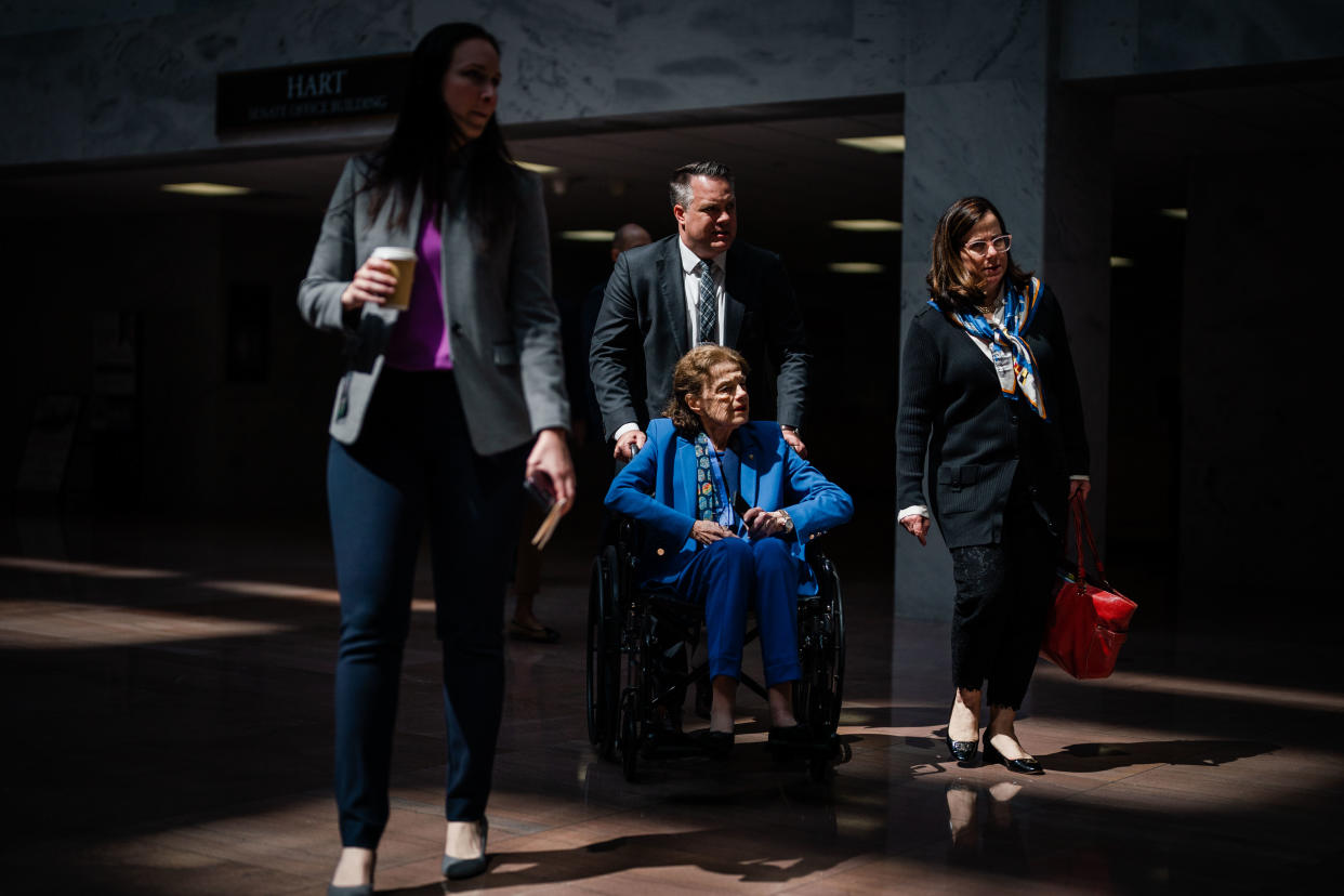  Dianne Feinstein, in a wheelchair, leaves a meeting with aides.